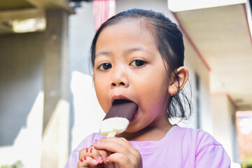 portrait of asian little girl earing ice cream