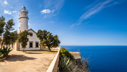 Front view of the forecourt of historic Puerto de Soller lighthouse called Far del Cap Gros sunlit in summer with copyspace at the right side and the mediterranean sea in the background at Mallorca. - obrazy, fototapety, plakaty