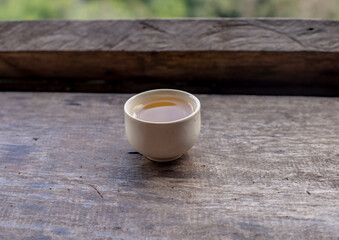 Fototapeta na wymiar Tea in a small teacup on a wooden table