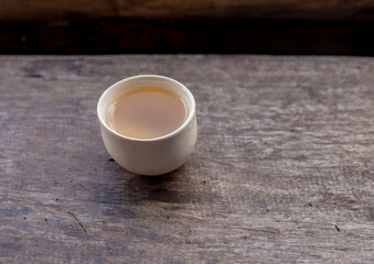Tea in a small teacup on a wooden table