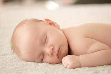 Closeup portrait of a cute infant baby sleeping. Beautiful white small baby sleeping at home. Portrait of a tiny caucasian boy resting. Face of a napping child, during an afternoon nap. Kid relaxing.