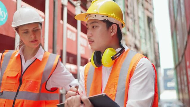 Dock manager woman and engineer worker looking at tablet and check stock in shipping container yard with smile. Import and export product. Manufacturing transportation and global business concept