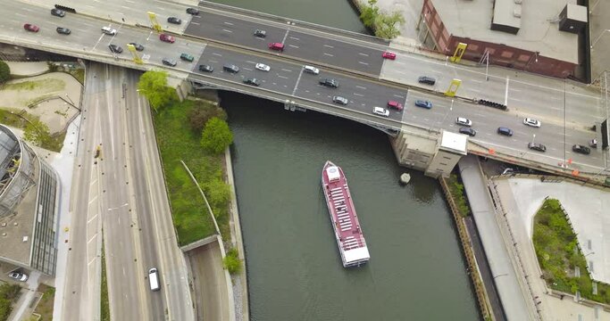 Big boat going under the bridge with cars riding on it. Lively traffic in Chicago, Illinois from bird's eye view.