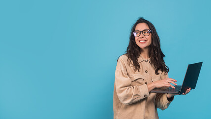 Cheerful young caucasian woman brunette student in casual and glasses with laptop looking at blank space