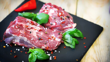 Soft focus. Pieces of raw lamb with spices on the board. Lamb marinade.