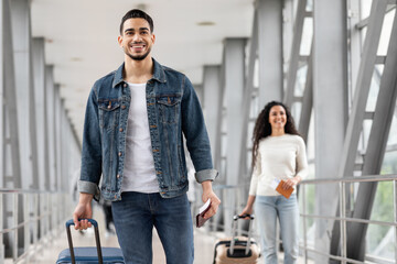 Fototapeta Smiling Middle Eastern Man And Woman Walking With Luggage At Airport obraz