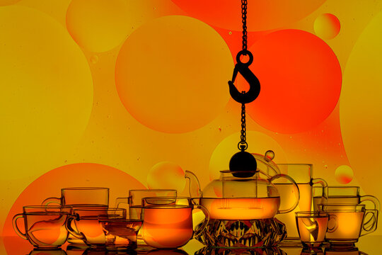 transparent teapot with tea glasses on a colored background