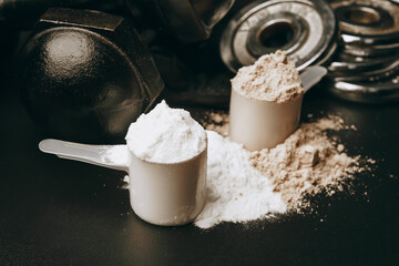 Scoop of protein powder and dumbbell background ,Fitness or healthy lifestyle concept. selective focus