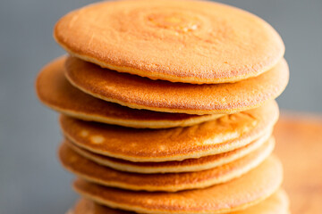 Pancakes for breakfast. Cover with pancakes. A stack of pancakes on a wooden board with honey. Honey pours on pancakes. Dessert. Favorite breakfast. Beautiful food cover.American breakfast. 