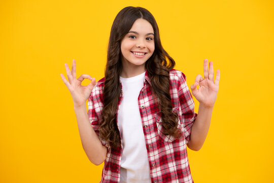 Young girl child show fingers ok symbol sign language isolated on yellow background. Funny teenager face. Happy teenager, positive and smiling emotions of teen girl.