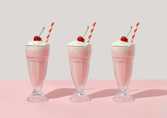Retro romantic creative pattern with strawberry milkshake with cherry on top on white and pastel...