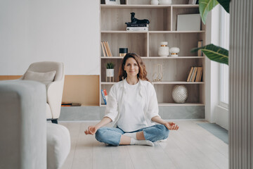 Comfort and serenity. Relaxed hispanic woman is practicing yoga and meditation on floor at home.