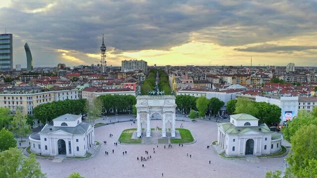 Aerial view shot of flying drone Milano italian city in Lombardia round square Arco della pace central historical arch classic complex with walking tourists imperial monumental architecture from above