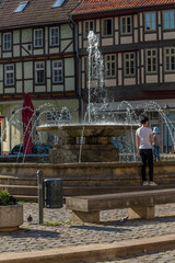Germany, Harz, Quidlingburg, June 15, 2022 - Mother and daughter play in the city's peat fountain.