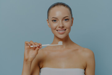 Dental. Young beautiful healthy woman holding toothbrush, brushing teeth with fluoride toothpaste