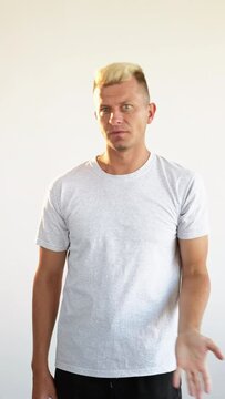 Male grooming. Metrosexual lifestyle. Skincare hygiene. Vertical portrait of confident athletic blond man enjoying touching stylish hawk haircut face showing thumb up isolated on light background.