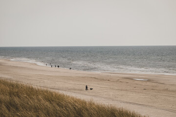 Fototapeta na wymiar Menschen gehen am Strand spazieren