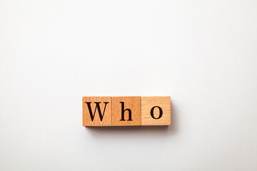 Whoの文字。誰が。疑問代名詞。3つの木製ブロックに書かれている。黒い文字。白い背景。