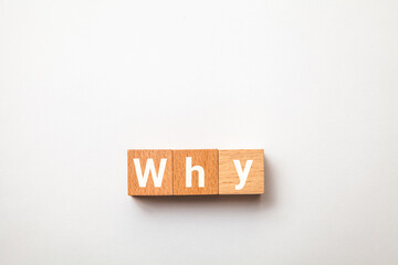 Whyの文字。なぜ。疑問符。3つの木製ブロックに書かれている。白い文字。白い背景。