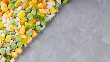 Mixed frozen vegetables with rice on a gray background. Frozen vegetables retaining all nutrients:...