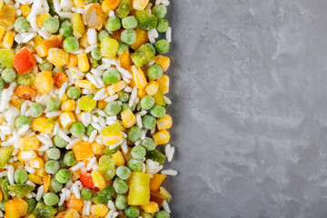 Mixed frozen vegetables with rice on a gray background. Frozen vegetables retaining all nutrients:...
