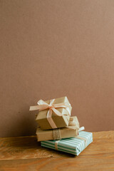 Stack of gift boxes on wooden table. brown wall background