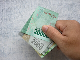 folding twenty thousand rupiahs and two thousand rupiahs in Indonesian currency