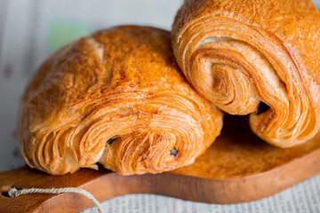 Fototapeta premium Croissant macro. French croissant with waves. Air baking. Croissant for puff pastry advertising. Croissant for a magazine.French breakfast with pastries. From puff pastry. Bun from France. Roll macro