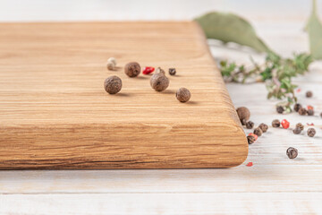 square wooden cutting board with spices on a white background. mockup with copy space for text, side view, close-up