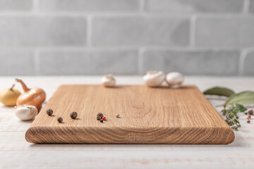 square wooden cutting board with mushrooms and spices on a white background. mockup with copy space...