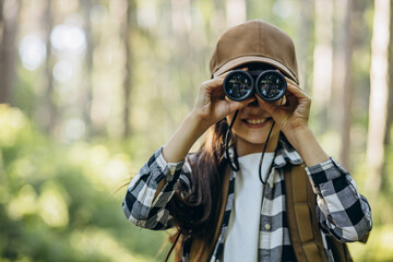 Girl looking through binoculars in park
