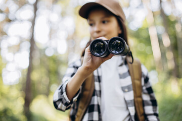 Girl looking through binoculars in park