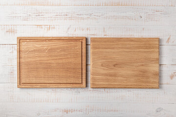 two rectangular cutting boards with edging on a white wooden table. mockup of a food background with copy space, top view