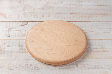 round cutting board on a white wooden table. mockup of a food background with copy space, side view