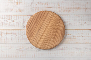 round cutting board on a white wooden table. mockup of a food background with copy space, top view