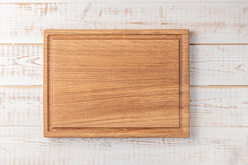 rectangular cutting board with edging on a white wooden table. mockup of a food background with copy space, top view