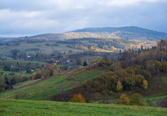 Cloudy and foggy autumn mountain countryside scene. Carpathians, Ukraine. Peaceful picturesque traveling, seasonal, nature and countryside beauty concept scene.