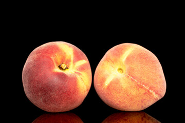 Two sweet organic peaches, close-up, isolated on black background.