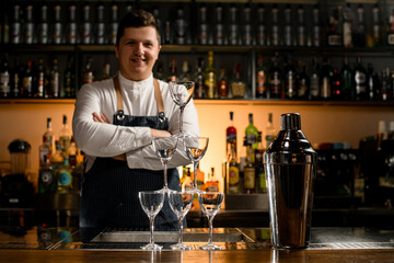 great view of the tower made of empty glasses and a shaker on the bar counter.