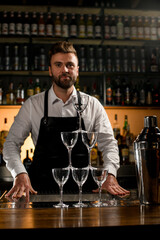 view of the tower made of empty glasses and a shaker on the bar counter.