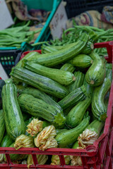 organic green zucchinis on a market stall, box with vegetables