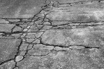 Dark worn asphalt road with cracks