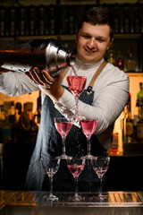 beautiful view of the tower made of glasses into which the bartender pours a drink
