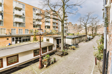 Panorama view of brick houses from an empty sidewalk street with trees and lanterns © Casa imágenes