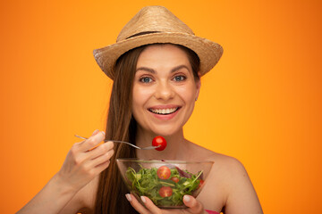 Smiling woman with bare shoulders wearing Mexican hat eating tomato on fork, big smile with teeth, isolated portrait, girl face portrait with natural no retouching skin.