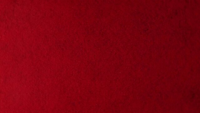 Abstract red background with gradien light from the texture of woolen cloth, top view, close-up.