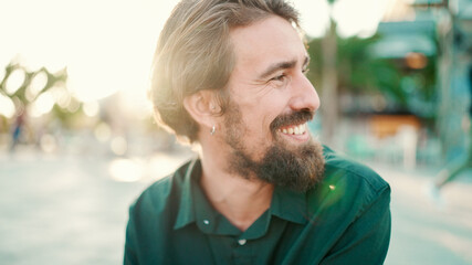 Close-up portrait of a smiling man with a beard on an urban city background with ice cream in his hands. Frontal close-up of a happy young hipster male testing ice cream on a warm sunny day