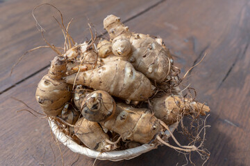 Group of fresh jerusalem artichokes on wooden table background, close up, top view