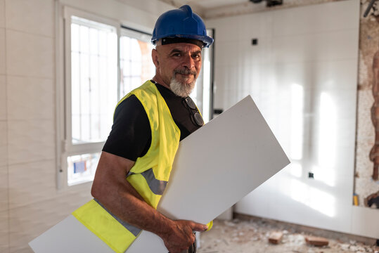 Construction worker poses with a large kitchen tile