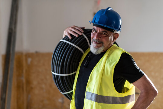 Construction worker poses with corrugated pipe destined for the electrical installation of a home